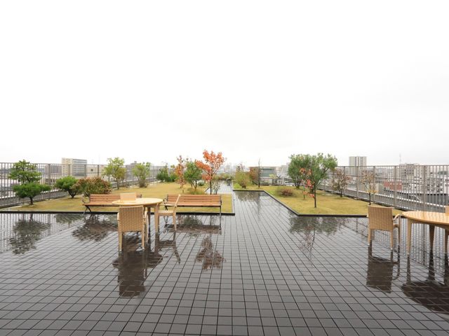庭木とベンチの屋上庭園 屋上庭園  広々とした屋上テラスは、心地良い緑と共に憩いの時間を提供します。天気のいい日には、新鮮な空気を感じながらリラックスできる空間です。