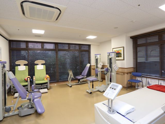 リハビリ器具が並ぶ部屋 トレーニング室 ゆったり配置されたリハビリ機器が、体力維持向上をサポート致します。快適な空間で、利用者様の身体機能の向上を目指せる環境です。