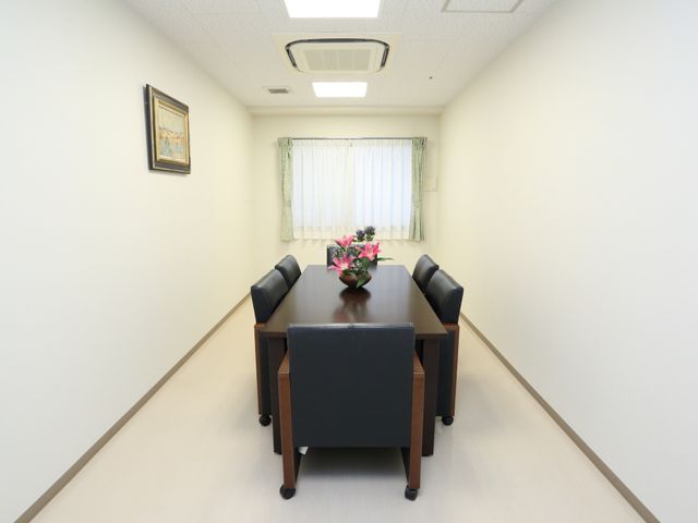 清潔な会議室風の空間 相談室 広々とした会議室のような空間は、日々のコミュニケーションや活動に最適です。窓からは自然光が差し込み、明るい環境が保たれています。