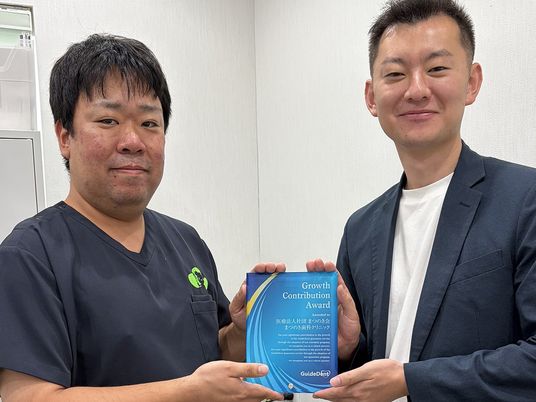 表彰状を持つ男性2人  