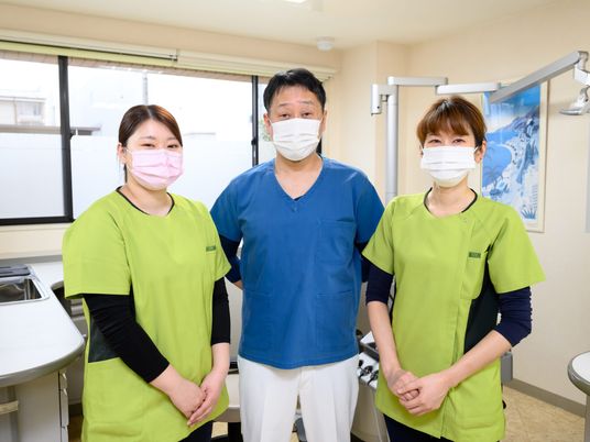 3人のスタッフが並ぶ機能訓練室  