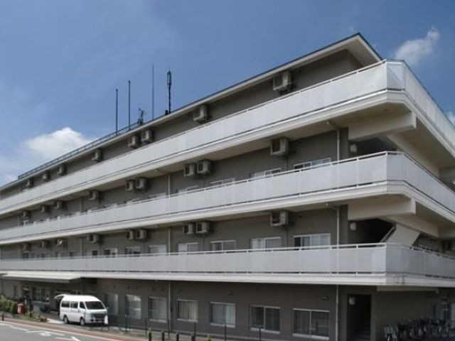 モダンな三階建て建物外観 外観 洗練されたデザインの三階建ての建物です。広々とした駐車スペースがあります。