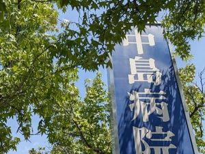 青い看板と木々の外観  