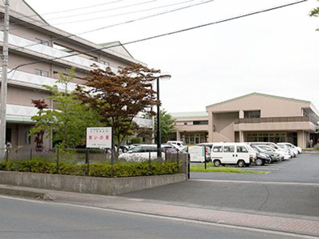 車が並ぶ建物の外観 外観 広々とした駐車スペースがあり、アクセスが便利な点が魅力です。素敵な環境で働けます。