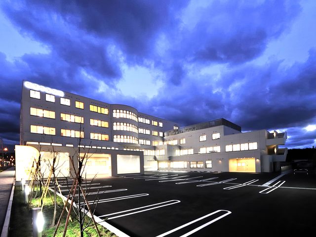 夜の外観 外観   夕方から夜にかけて窓明かりが目立つ、白い外壁の建物です。広い駐車スペースがあり、働く方の車の出入りもしやすそうです。
