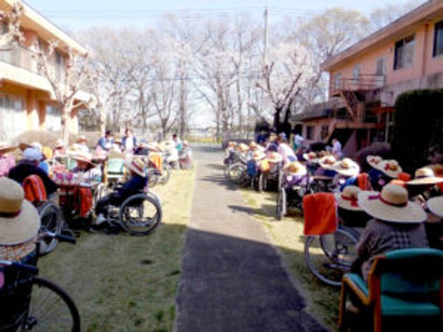 車椅子利用者の庭 庭 大きな庭で、多くの利用者がくつろいでいます。緑の中での休憩は、気持ちをリフレッシュさせます。