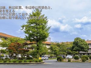 緑に囲まれた建物の外観  