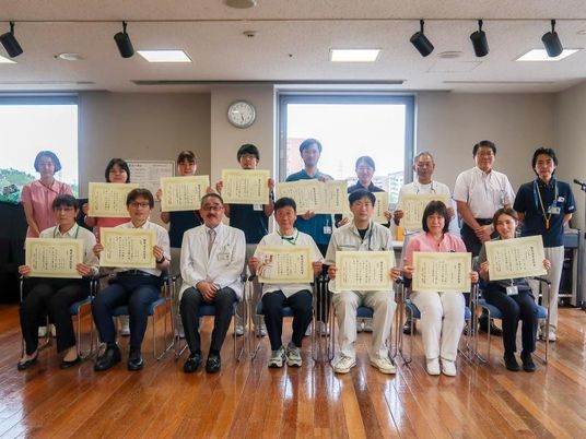 表彰状を持つ職員集合  