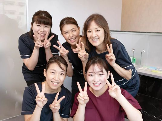 笑顔の職員が並ぶ洗面台  