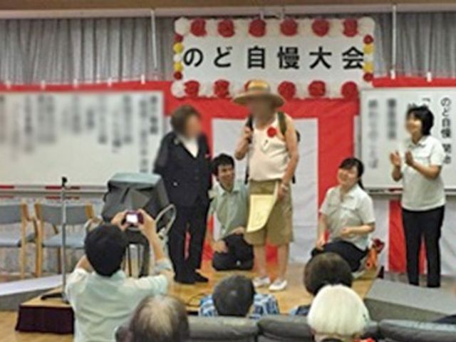のど自慢大会の様子 多目的室 楽しいイベントで盛り上がる様子です。スタッフも利用者と一緒に交流し、和やかな時間を過ごしています。