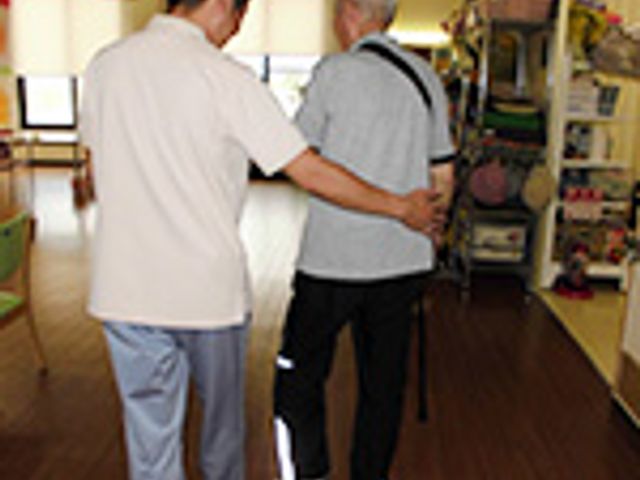 職員と利用者が歩く廊下 廊下 職員が丁寧に利用者をサポートしています。温かい雰囲気の中、安心して過ごせる環境です。