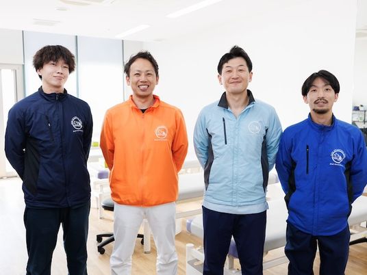 スタッフ4人が並ぶ機能訓練室  