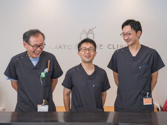 笑顔のスタッフ3人が並ぶ受付  