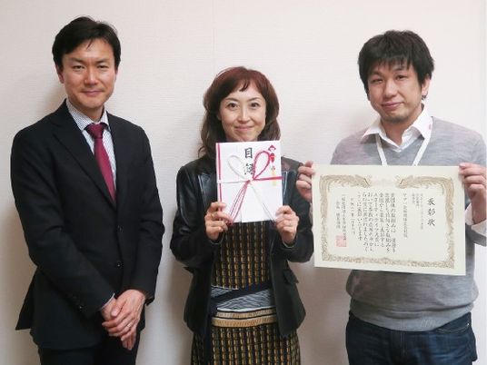 表彰状を持つ3人  