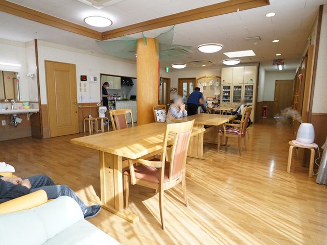 木目調の広々とした食堂 共有スペース 広々としたダイニングルームでは、皆様が並んで食事を楽しまれています。自然光が差し込む窓と木目調のインテリアで、暖かみのある空間を提供しております。