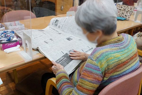 新聞を読む高齢者