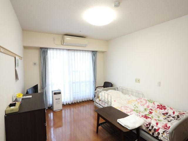 明るく清潔な居室 居室 落ち着いた雰囲気の居室で、ゆったりとした時間を過ごせます。窓辺には彩りを添える花があり、居心地の良さが感じられる空間です。