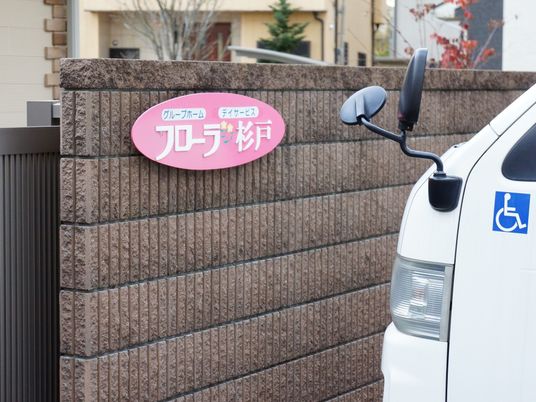 ピンクの看板と白い車