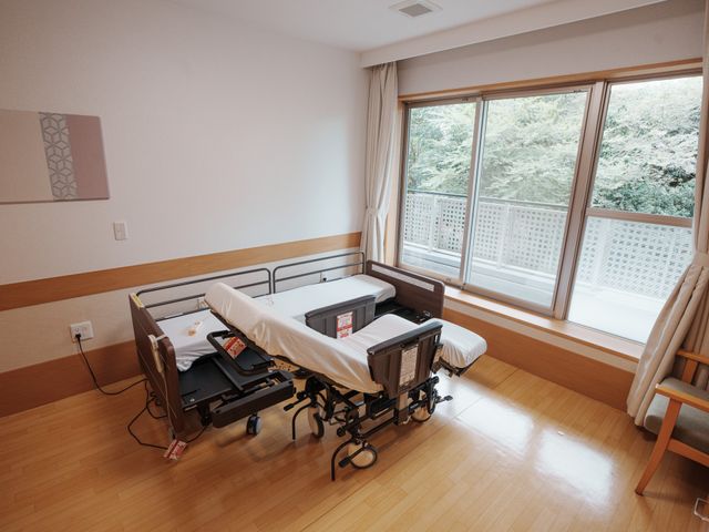 綺麗な居室窓とベッド 洋室 広々とした窓から自然光が入る居室です。清潔感のある空間で、日々の生活に安らぎを提供しています。