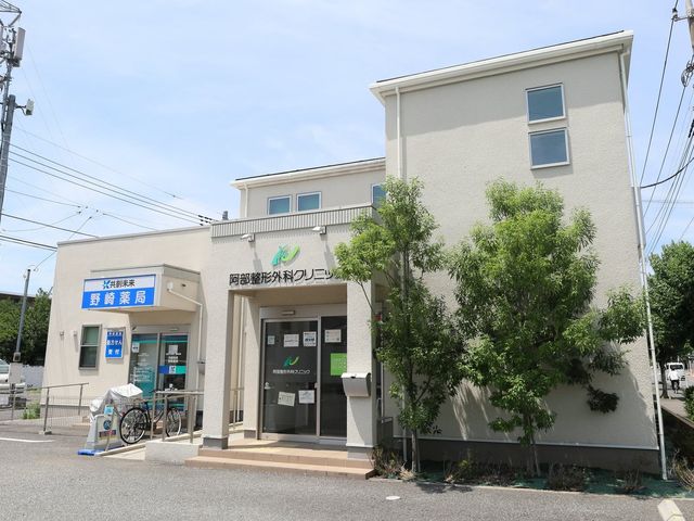 看板と外観の風景 外観 緑に囲まれた建物は、明るく開放的な印象を与えます。静かな環境で働くことができそうです。