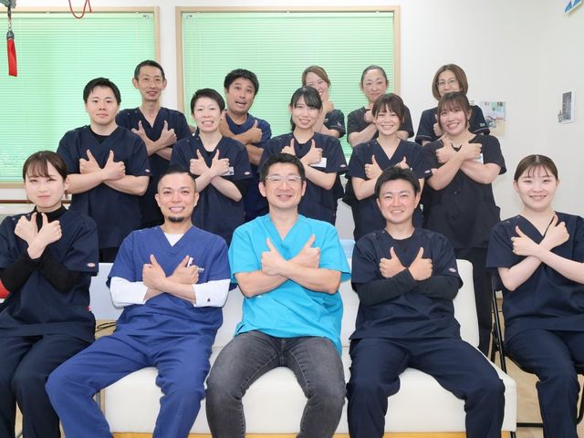 スタッフの笑顔あふれる空間 スタッフイメージ 和やかな雰囲気の中、多くのスタッフが笑顔で集まっています。明るく協力的な職場環境を感じさせます。