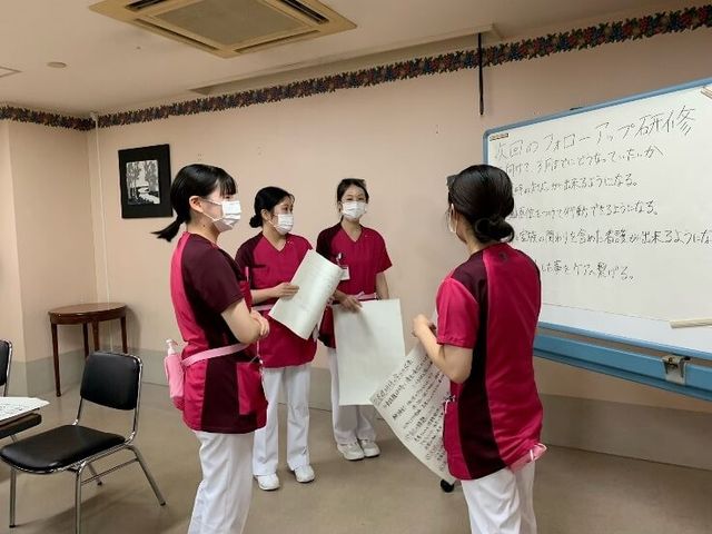 研修中の職員たち 多目的室 多目的室   白板を使って意見を出し合う研修の様子です。職員同士で学び合える雰囲気が伝わります。