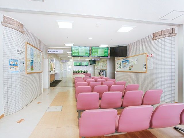ピンク椅子の待合ロビー ロビー   明るい待合ロビーに、整列したピンクの椅子が並んでいます。案内表示や掲示板もあり、来訪者が使いやすい印象です。