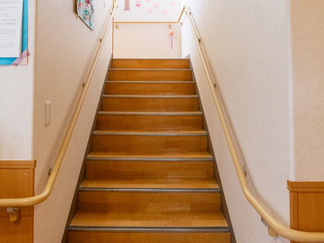手すり付きの階段 廊下 両側に手すりが設置された階段があり、安全に移動できます。壁にはサポートとなる飾りもあります。