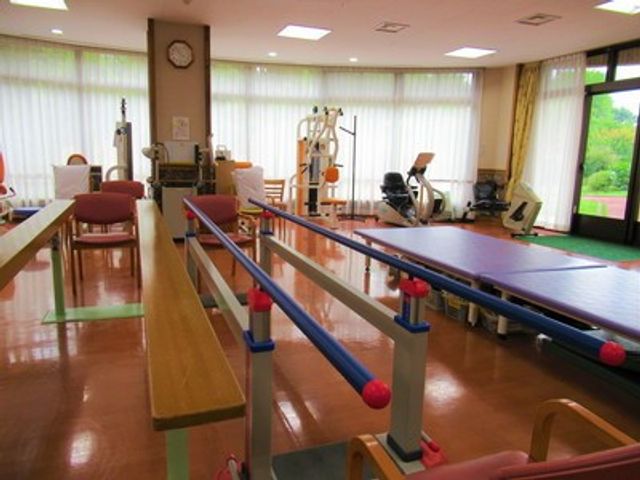 訓練用の器具が並ぶ部屋 機能訓練室 自然光が差し込む明るい空間で、リハビリテーションに最適な設備が整っています。