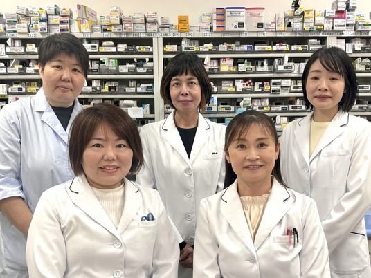 薬剤棚の前のスタッフ  