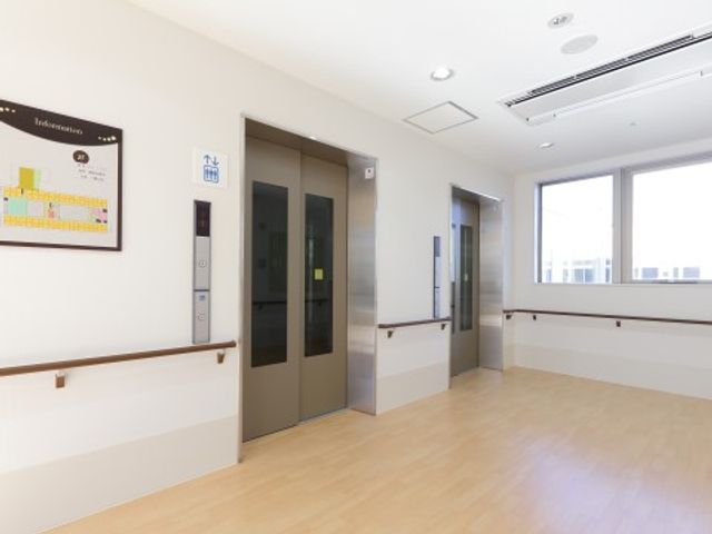 エレベーター前の廊下 エレベーター ゆったりとした空間に一列に設けられた手すりは、安全に移動を支えます。明るく開放的な窓からは、自然光が差し込んでおります。