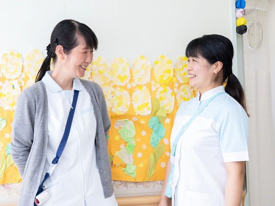 笑顔の職員2人が談笑する廊下  