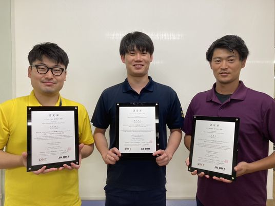 認定証を持つ職員3人の集合  