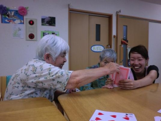 笑顔でカード遊びする人々