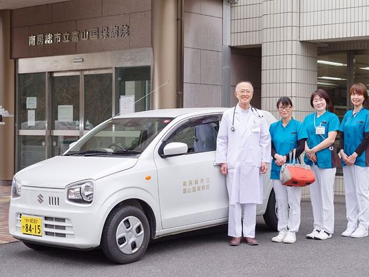 スタッフと送迎車の外観  