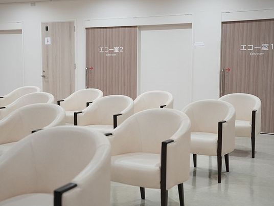 明るいラウンジの椅子並ぶ室内  