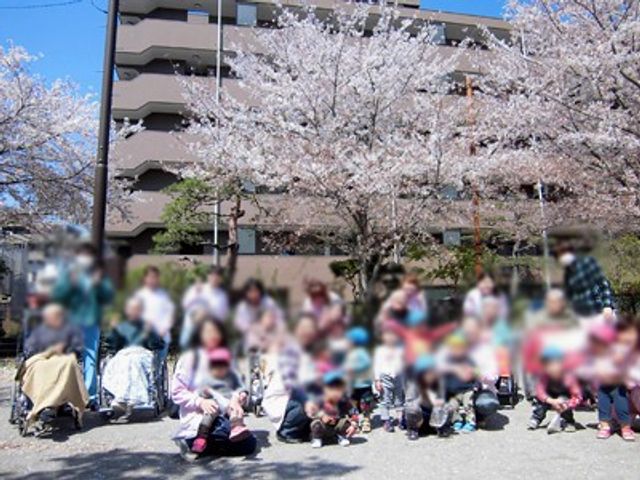 満開の桜と集合風景 中庭 満開の桜の下、多くの人々が集う和やかな風景です。憩いのひとときを過ごせそうです。