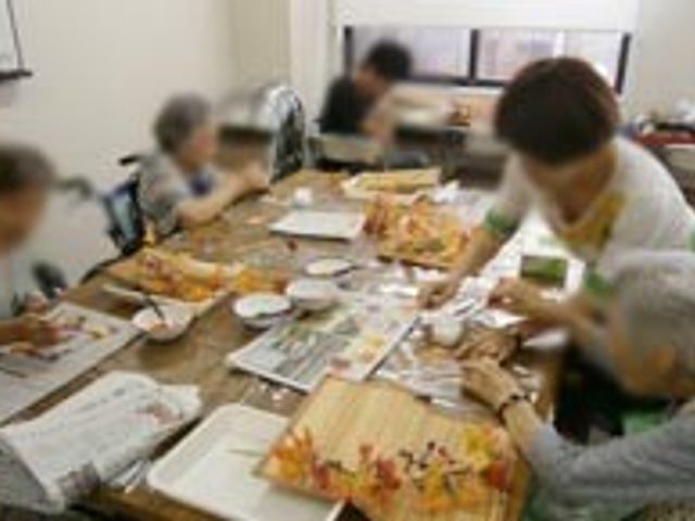 アクティビティ中の居室 居室 明るい居室で、利用者が楽しむアクティビティが行われています。スタッフも一緒に参加しています。