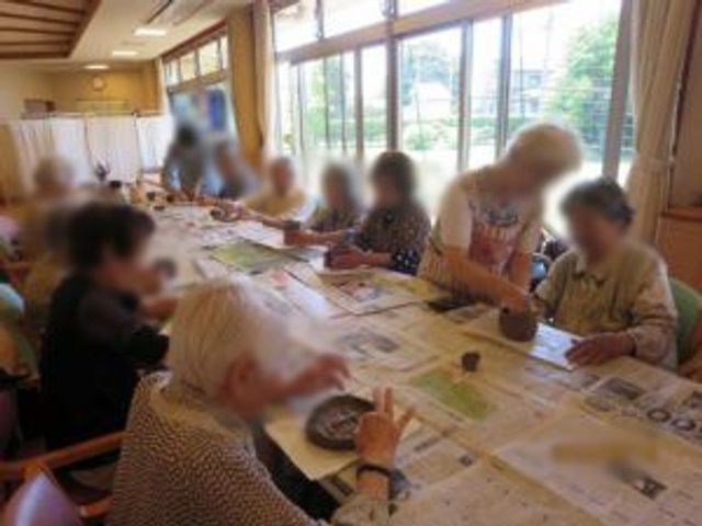 利用者が活動中の様子 ダイニングルーム 自然光が溢れる広々としたスペースで、利用者が笑顔で活動しています。温かな雰囲気が特徴です。