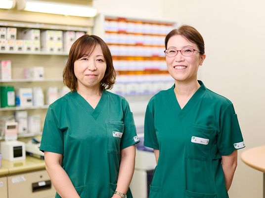 制服のスタッフが並ぶ室内  