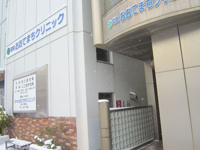 雪の外にある建物入口 外観   雪が降る中、建物の入口と案内看板が見えます。落ち着いた外観で、来訪時の場所が分かりやすい印象です。