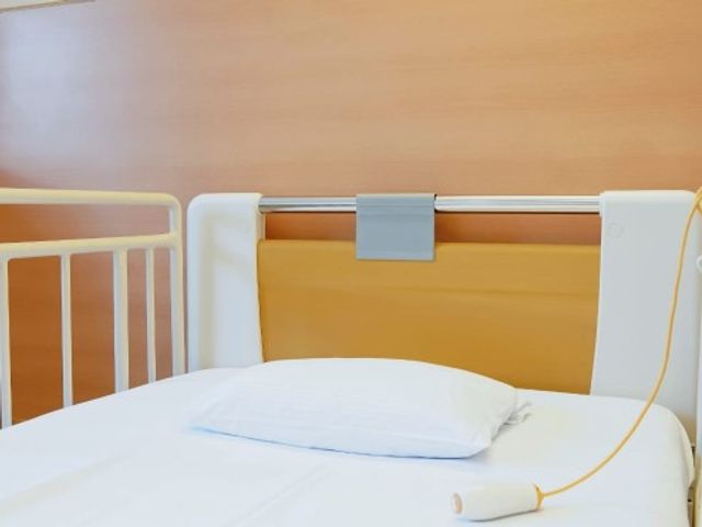 ベッドと手元スイッチの居室 居室   白い寝具とシンプルなベッドまわりが見え、手元で操作できるスイッチも備わっています。落ち着いて休める空間づくりがうかがえます。