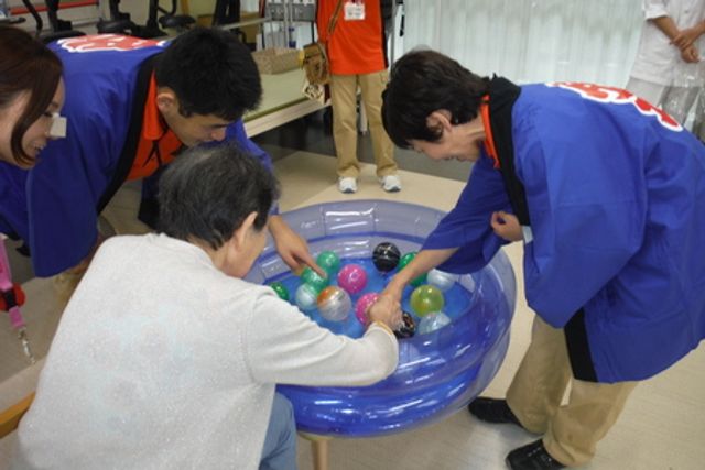 楽しそうな様子の共有スペース ラウンジ 和気あいあいとした雰囲気の中、スタッフと利用者が一緒に活動を楽しんでいます。リラックスできる空間が広がります。