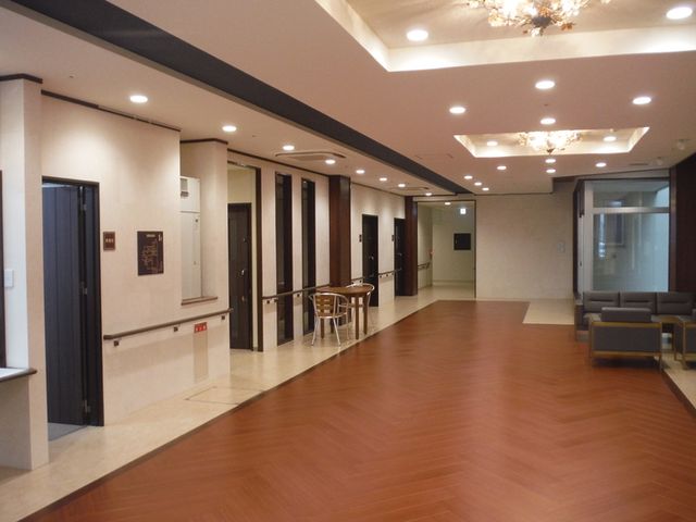 広々とした廊下 廊下 自然光が入る落ち着いた空間です。椅子に座ってくつろぐスペースもあり、スタッフ同士のコミュニケーションが盛んになります。