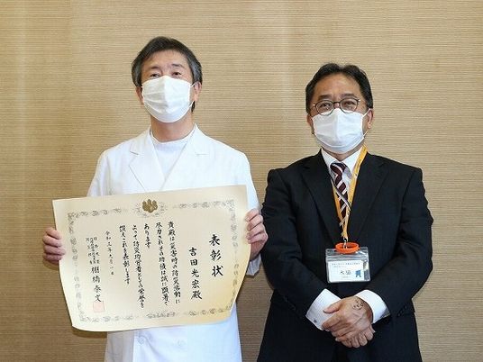表彰状を持つ職員