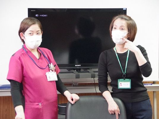 スタッフ2人の会話中の休憩室  