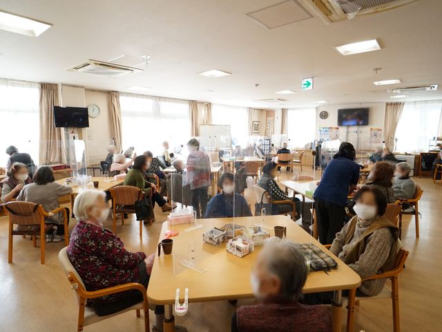 共用スペースの様子 共有スペース ゆったりとした椅子に座る人々がくつろぐ憩いの場です。手元には飲み物を置き、穏やかな時間を過ごされています。