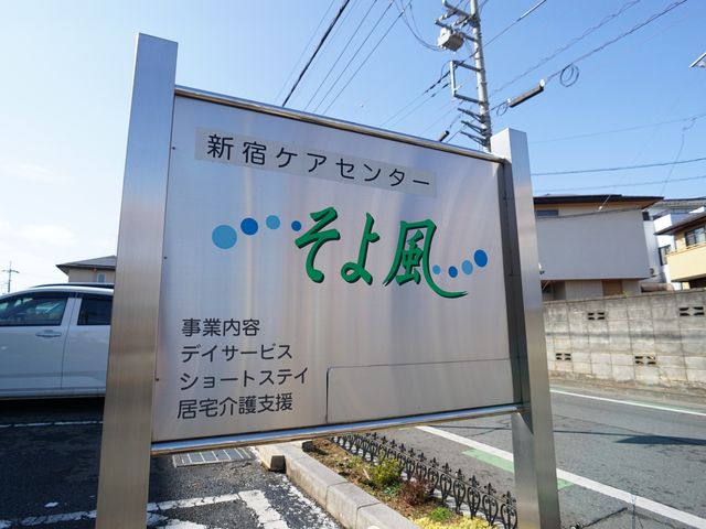 看板の前の景色 ロゴ 心温まる雰囲気を感じさせる看板が設置されており、多彩なサービスが提供されることが伺えます。