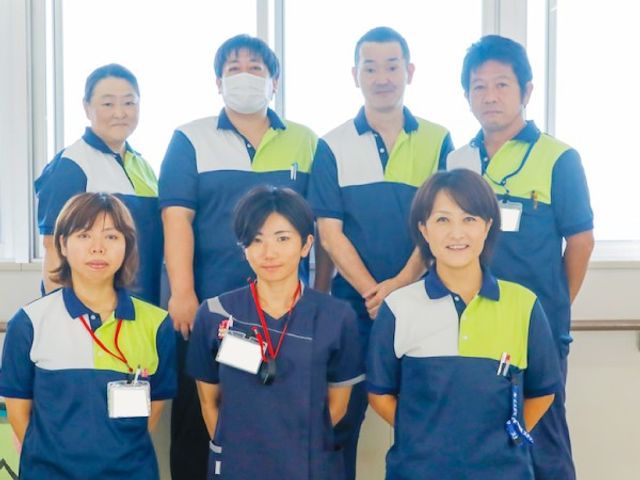 スタッフ集合 スタッフイメージ   ユニフォーム姿のスタッフが並ぶ様子です。明るい窓際で、働く雰囲気が伝わります。