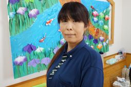 壁画の前の女性スタッフ